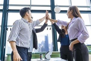 el equipo de jóvenes empresarios asiáticos y la puesta en marcha tienen una reunión de negocios y se animan unos a otros para tener buena energía para lograr un concepto exitoso del plan de marketing foto