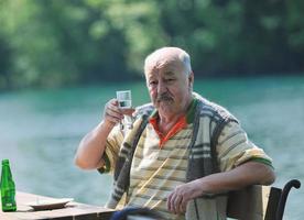 el anciano come postre en el restaurante al aire libre foto