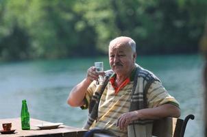 senior man eat desser at outdoor restaurant photo