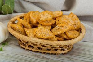 Croutons in a basket on wooden background photo