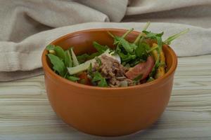 Tuna salad in a bowl on wooden background photo