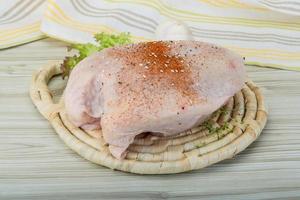 Raw chicken breast on wooden board and wooden background photo