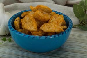 Croutons in a bowl on wooden background photo