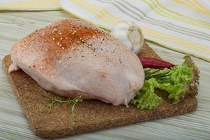 Raw chicken breast on wooden board and wooden background photo