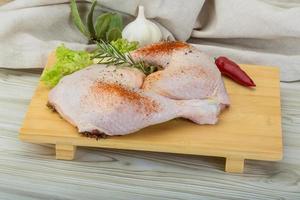 Chicken thigh on wooden board and wooden background photo