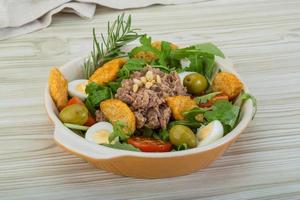 Tuna salad in a bowl on wooden background photo