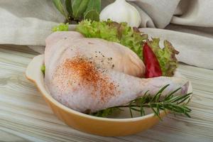 Chicken thigh in a bowl on wooden background photo