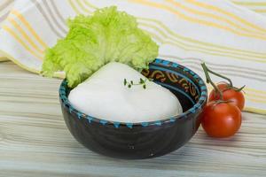 Mozzarella in a bowl on wooden background photo