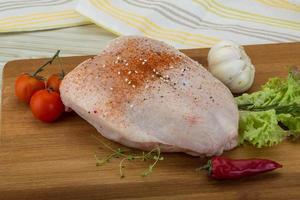 Raw chicken breast on wooden board and wooden background photo