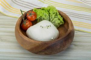 mozzarella en un bol sobre fondo de madera foto