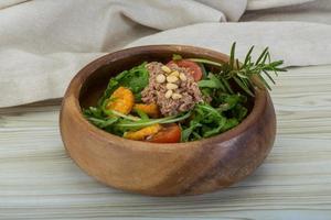 Tuna salad in a bowl on wooden background photo