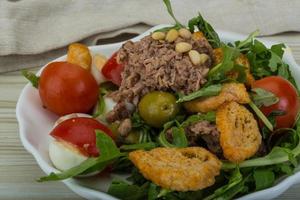 Tuna salad in a bowl on wooden background photo