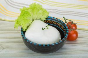 Mozzarella in a bowl on wooden background photo