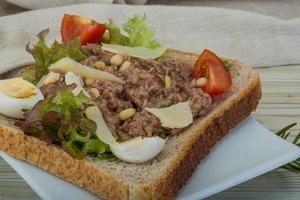 Tuna sandwich on the plate and wooden background photo