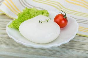 mozzarella en un bol sobre fondo de madera foto