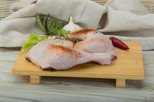 Chicken thigh on wooden board and wooden background photo
