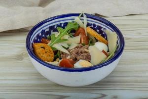 Tuna salad in a bowl on wooden background photo