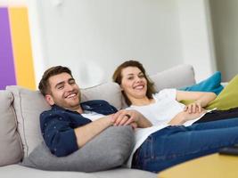 retrato de una joven pareja de recién casados de 25 años enamorada posando para una sesión de fotos sentada en un sofá en modernos apartamentos tipo estudio