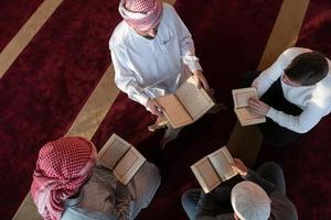 musulmanes en la mezquita leyendo el corán juntos foto