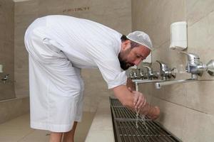 A Muslim takes ablution for prayer. Islamic religious rite photo