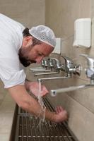 A Muslim takes ablution for prayer. Islamic religious rite photo