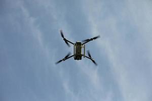 Drone in sky. Quadro copter flies in air. Surveillance from height. Four propellers. photo