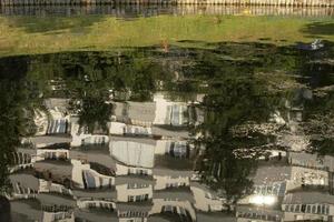 Reflection of house in water. Surface of lake. City Pond. photo