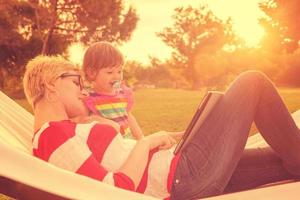 mom and a little daughter relaxing in a hammock photo