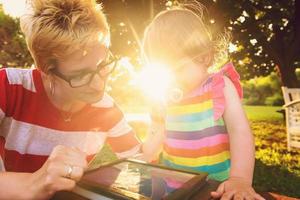 mom and her little daughter using tablet computer photo