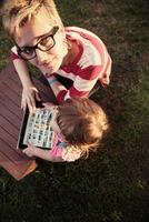 mom and her little daughter using tablet computer photo