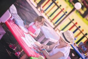 mamá y su pequeña hija dibujando imágenes coloridas foto