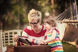mom and her little daughter using tablet computer photo