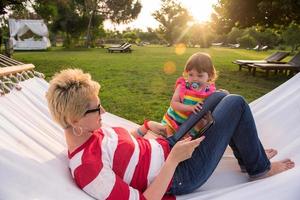 mamá y una pequeña hija relajándose en una hamaca foto