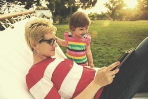 mamá y una pequeña hija relajándose en una hamaca foto