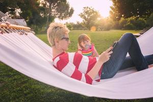 mamá y una pequeña hija relajándose en una hamaca foto