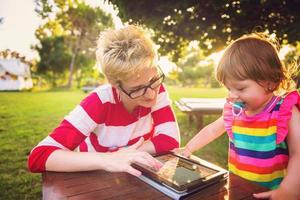 mom and her little daughter using tablet computer photo