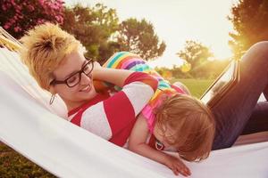 mamá y una pequeña hija relajándose en una hamaca foto