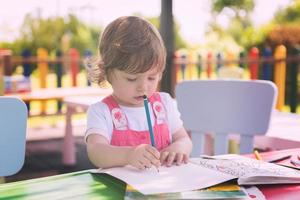 niña dibujando imágenes coloridas foto