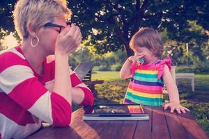 mom and her little daughter using tablet computer photo