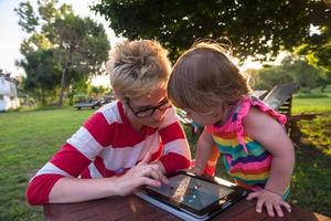 mom and her little daughter using tablet computer photo