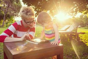 mom and her little daughter using tablet computer photo