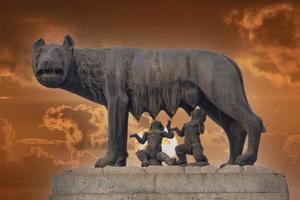 she wolf roman empire symbol breast feeding newborn romolus and remus statue on red sunset background photo