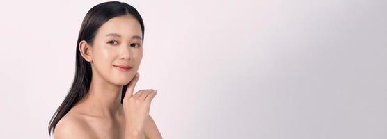 hermosa mujer asiática joven con piel limpia y fresca sobre fondo blanco. foto