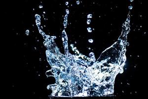 Splashing water on a black background. water droplets scattered on a black background photo