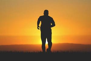 la silueta de los hombres estoy trotando para mantenerme saludable por la noche. los hombres hacen ejercicio corriendo. concepto de salud foto