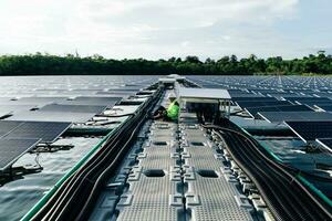 el retrato de un joven ingeniero comprueba los paneles solares fotovoltaicos. concepto. servicio de electricidad de tecnología de energía renovable, energía verde. foto