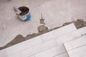 Ceramic wood effect tiles and tools for tiler on the floor photo