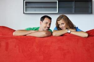 happy couple relax on red sofa photo