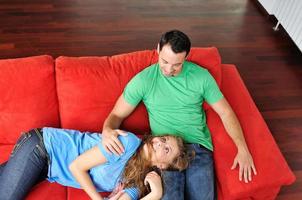 happy couple relax on red sofa photo