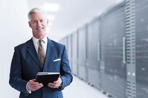 Senior businessman in server room photo